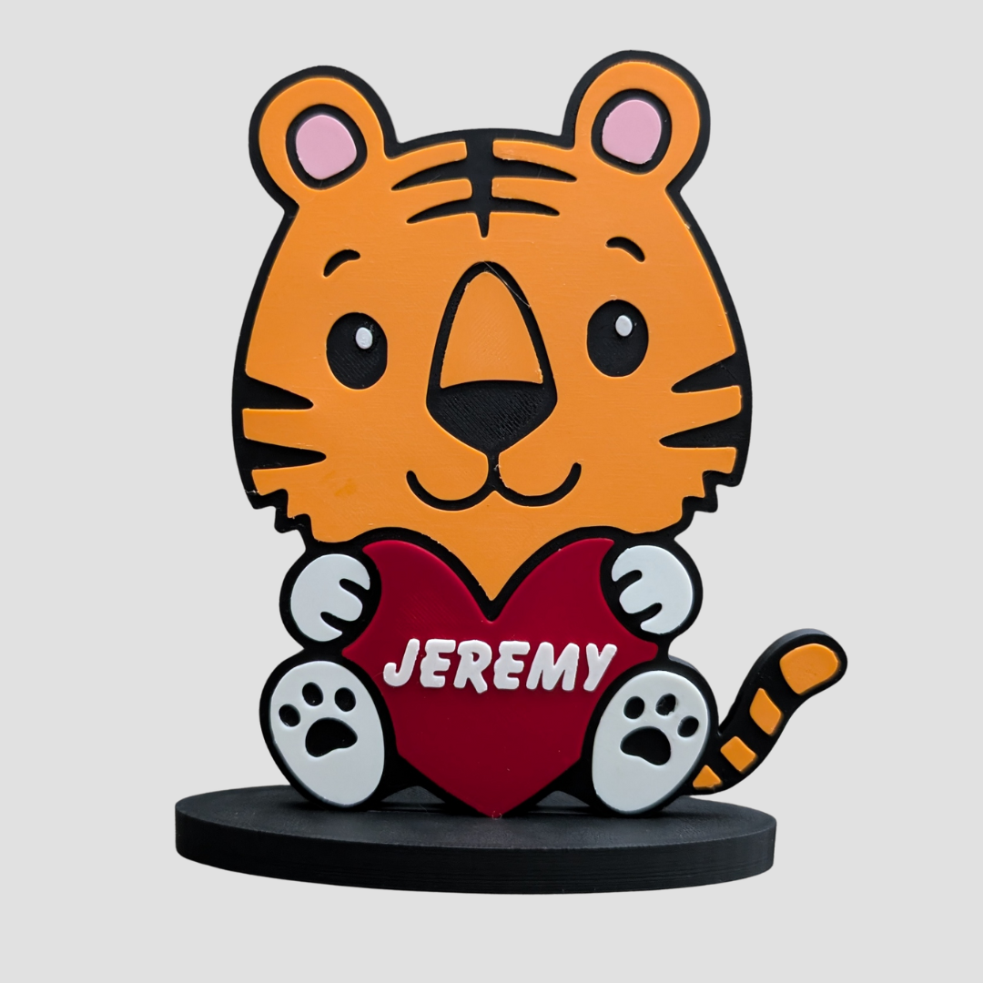 Personalised tiger ornament holding a red heart with the name 'JEREMY', for safari-themed children's room decor.