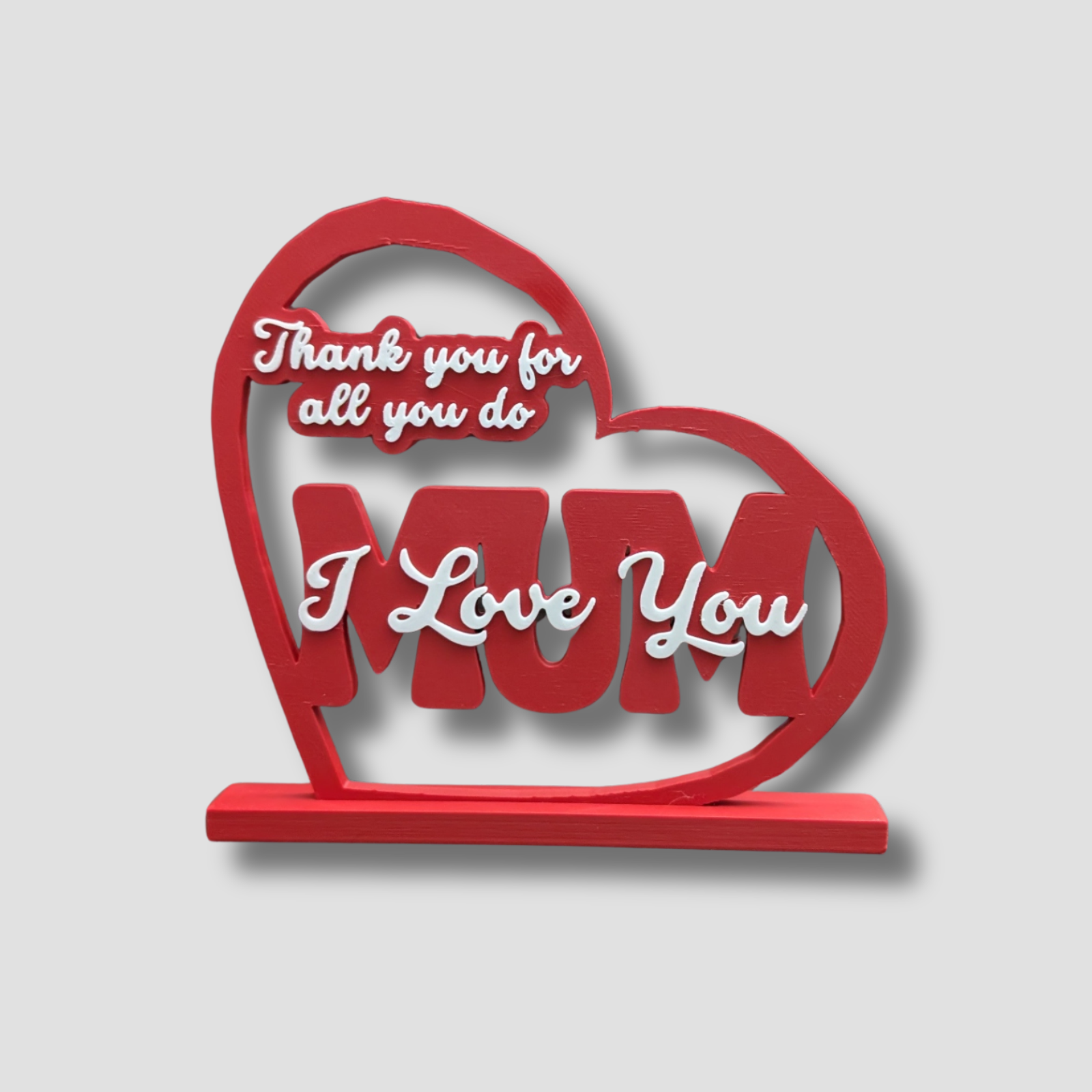 Red heart-shaped decorative piece with 'I Love You' and 'MUM' text on a light gray background