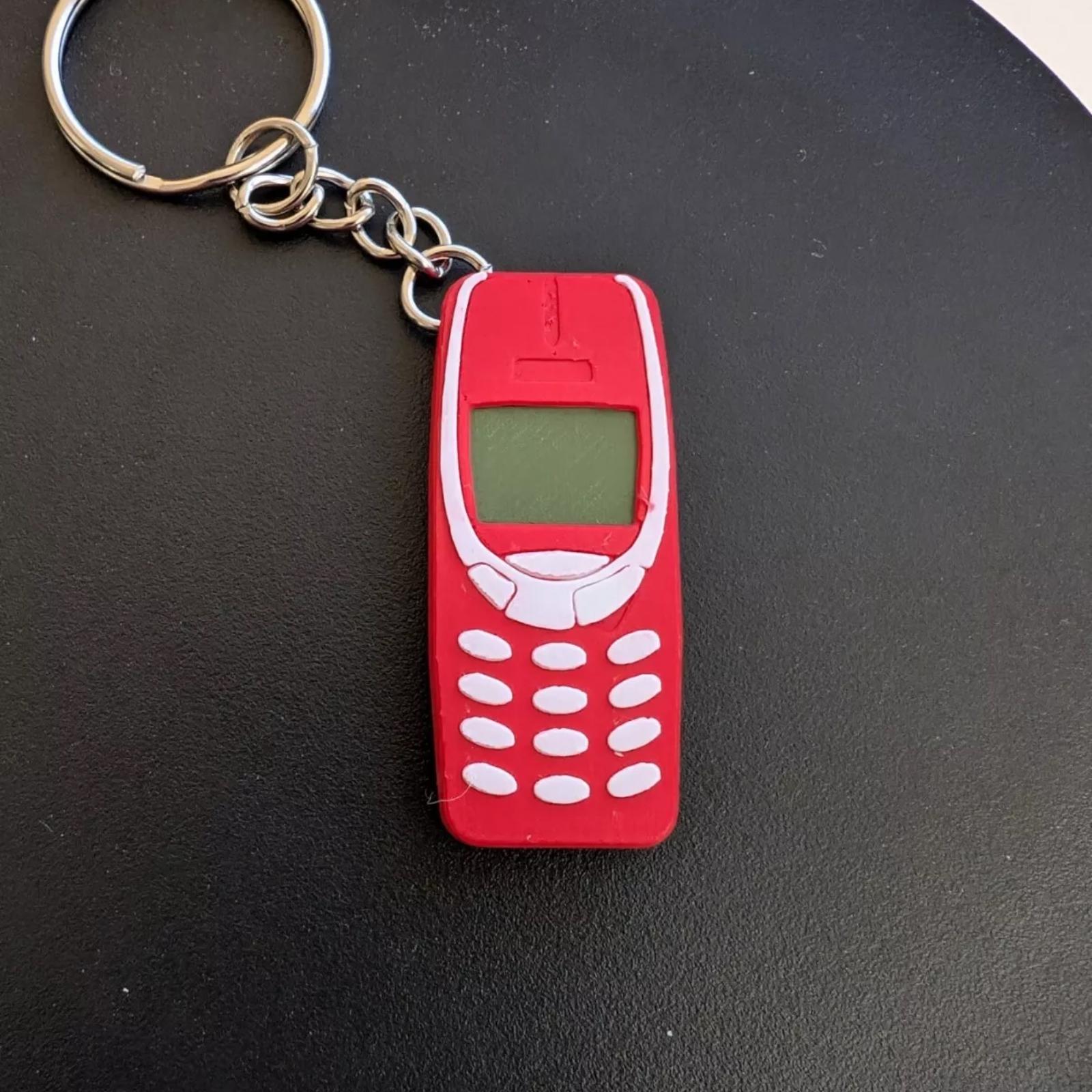 Red mobile phone keyring with white buttons, featuring a retro design, ideal for a quirky gift.