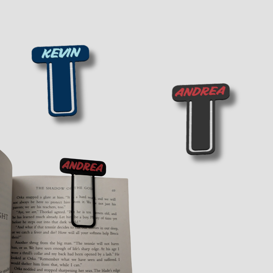 Two letter 'T' shaped bookmarks with names 'Kevin' and 'Andrea' on a book.