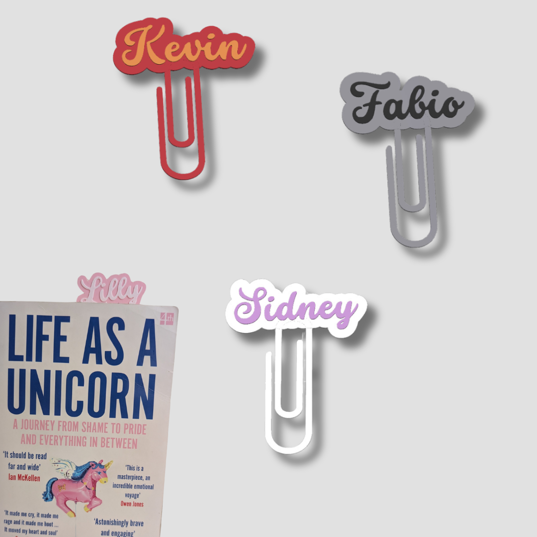 Group of four personalised paperclip bookmarks in red ('Kevin'), grey ('Fabio'), white/purple ('Sidney'), and pink ('Lilly').