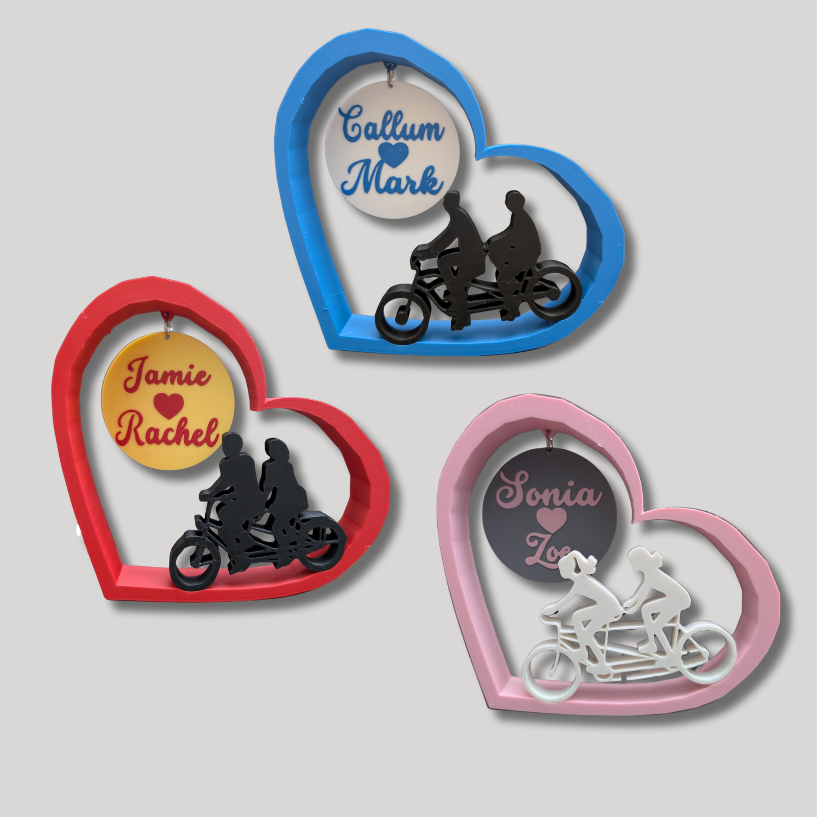 Heart-shaped frames with silhouettes of people on bikes and personalised names.