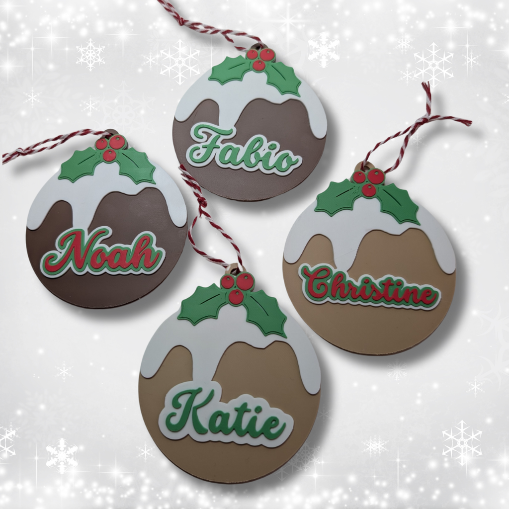 Decorative Christmas pudding ornaments with names on a snowy background