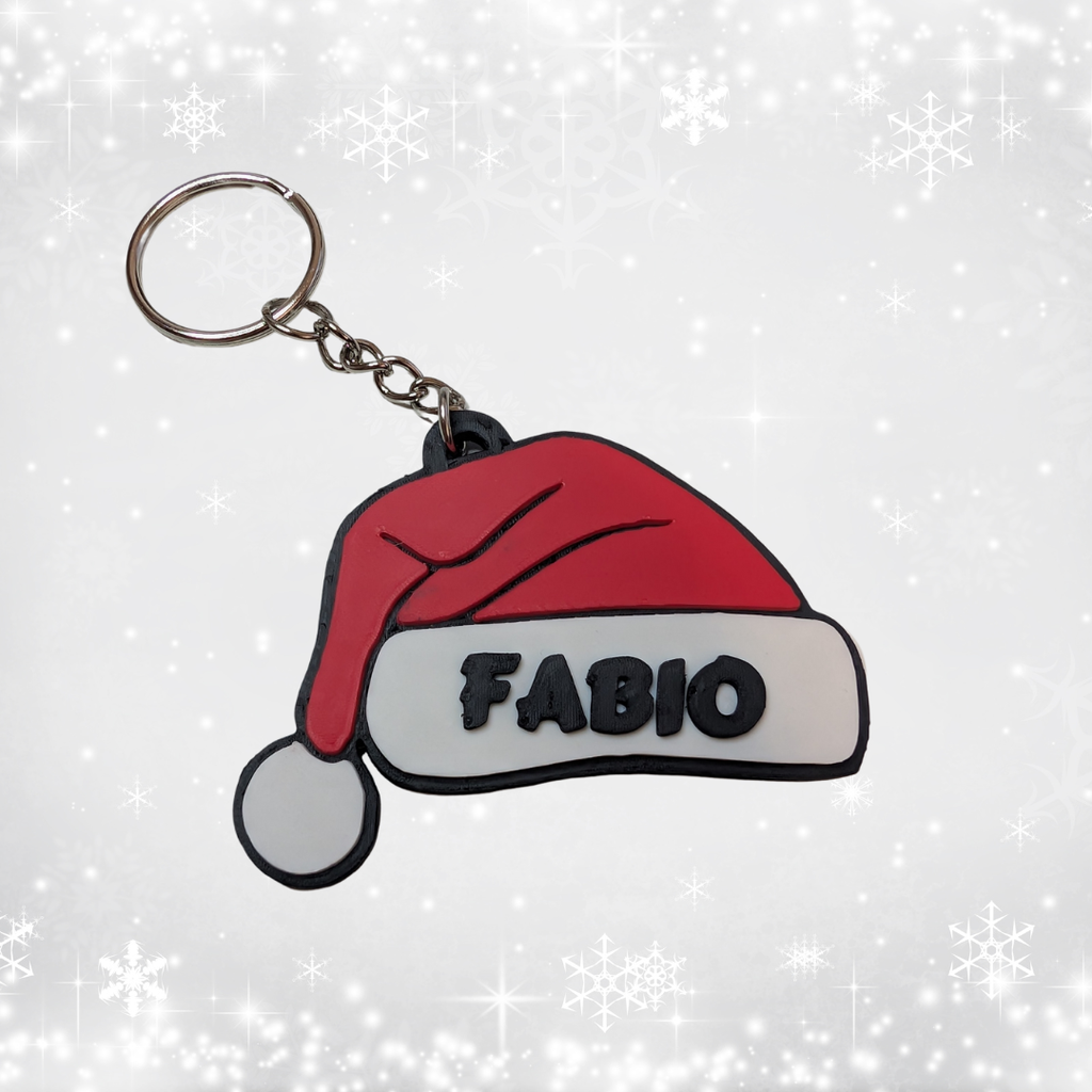 Keychain with red Santa hat and 'FABIO' text on a white background