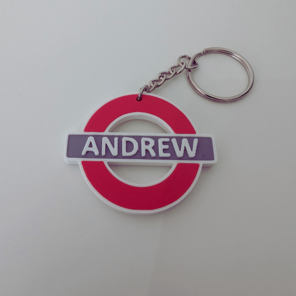 Keychain with a red circle and 'ANDREW' text on a white background