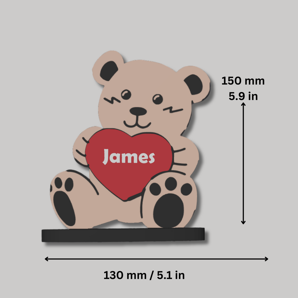 Bear-shaped decorative item with a heart and 'James' text, shown with measurements on a gray background.