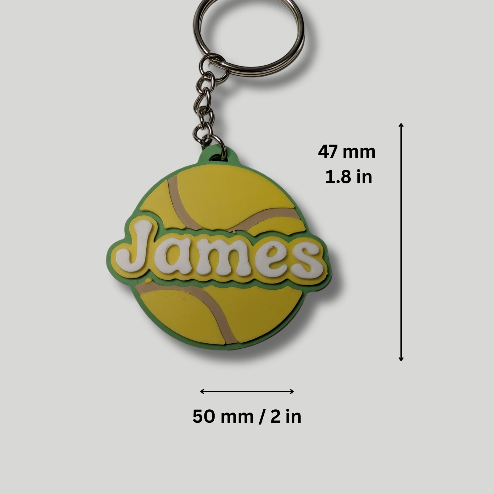Yellow keychain with 'James' text and measurements on a gray background